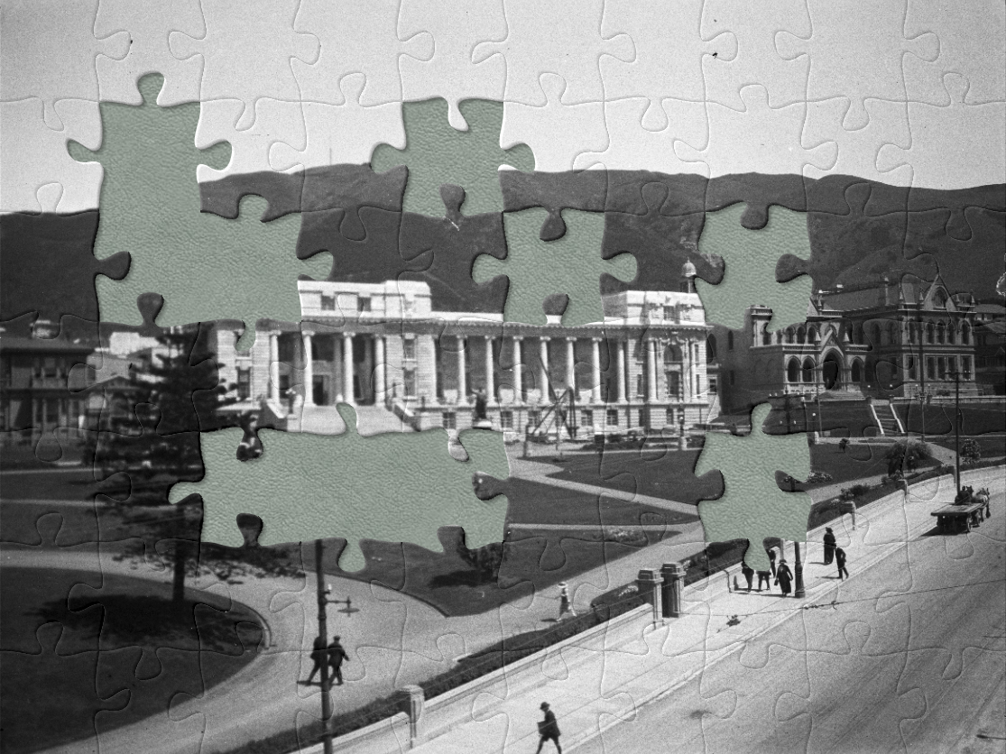 A black and white photo of a large building with very tidy lawns in front of it and jigsaw pieces 'cut' out of it