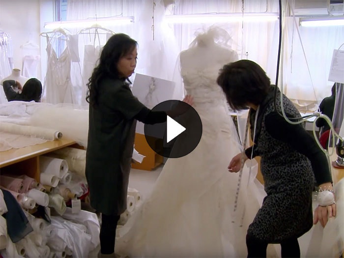 Two ladies work on a wedding dress