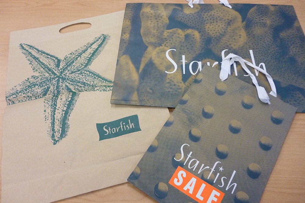 A photo of a cotton bag, and two paper bags with Starfish logo and promotion on them.
