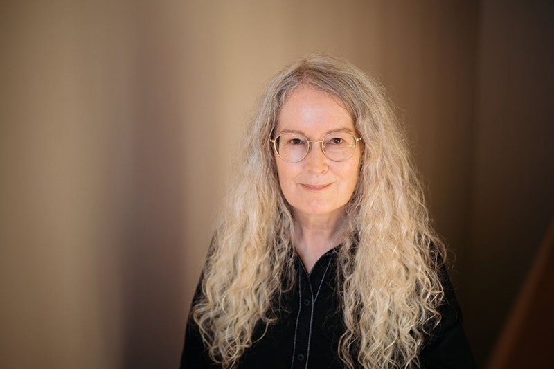 Elizabeth Knox, photo by Ebony Lamb A woman with long white blonde hair is smiling at the camera.