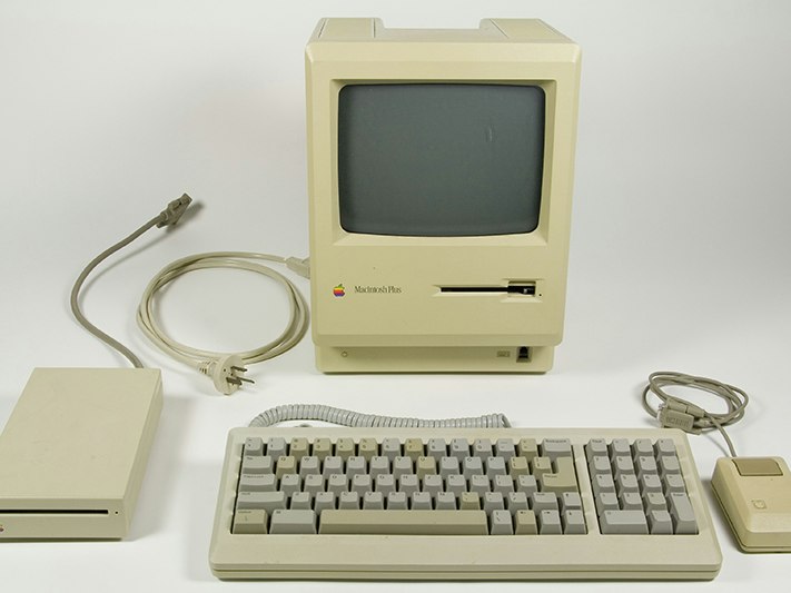 Macintosh Plus computer, 1986, United States, by Apple Computer, Incorporated. Gift of Don Long, 2011. CC BY-NC-ND 4.0. Te Papa (GH021018/1-5) An old beige Macintosh computer monitor, keyboard, disc drive, and mouse.