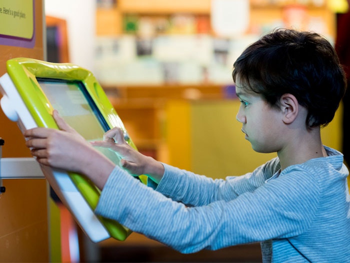 Child in Inspiration Station, 2016. Photograph by Mike O'Neill. Te Papa Boy using computer