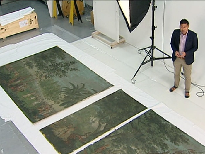The Dufour wallpaper arriving at Te Papa, 2016. Courtesy of TVNZ A news reporter stands by the Dufour wallpaper