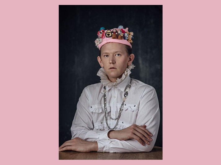 This Is How I Felt, May 2020, New Zealand, by Andi Crown. Te Papa (O.048781) Portrait of Chris Parker wearing a felt hat. The hat features tiny versions of the key New Zealand public figures during Covid-19, a bag of flour, a tiny self-portrait of Chris wearing his orange hoodie, and a tiny official Covid-19 symbol