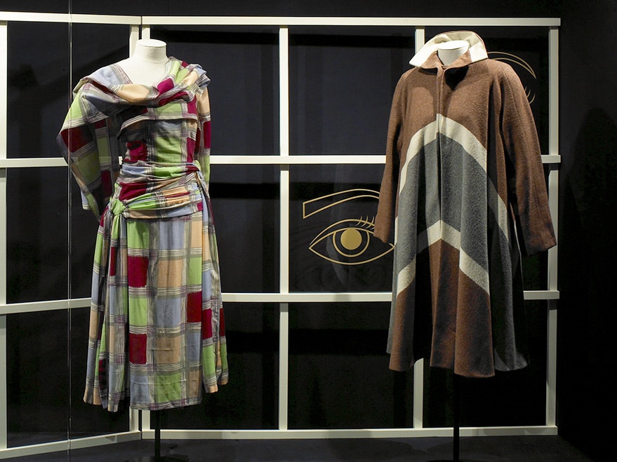 fashion_tile_1_ma_i080412.jpg two fashion dummies with two outfits on in front of a steel frame and a dark background