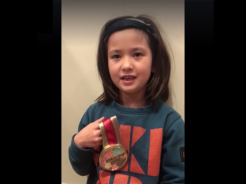 Make your own Anzac Day medal for an essential worker or someone in your house A young girl in a sweatshirt inside a house holding a homemade medal