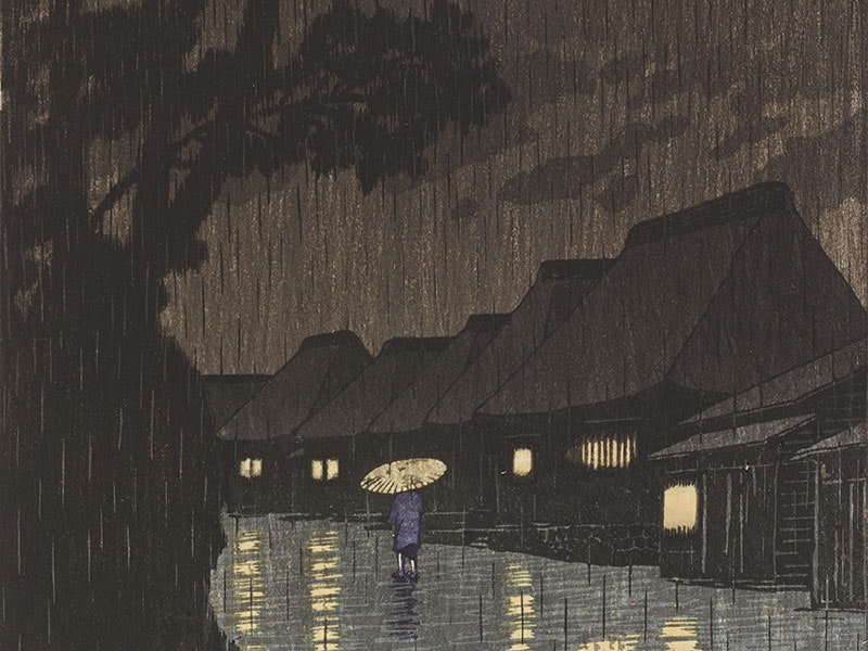 Kawese Hasui, Rain at Maekawa, Sochu, 1932, ink on paper. Te Papa (2016-0008-11) Person walks down a path in heavy rain, flanked by very tall trees on the left and houses with their lights on to the right