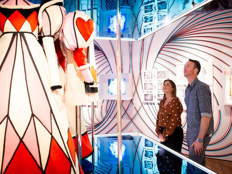Visitors with gowns from the 1966 NBC television musical production Alice Through the Looking Glass. Te Papa People look at a Queen of Hearts costume