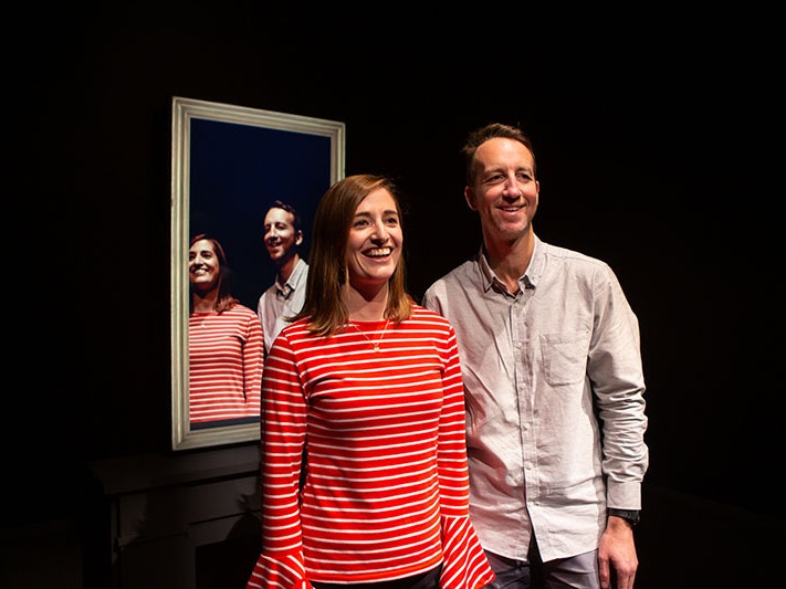 Inside Surrealist Art, 2021. Photo by Jo Moore. Te Papa A man and a woman, smiling, look beyond the camera with their backs to a mirror. The mirror showing what we see, an impossible view of them looking in the same direction