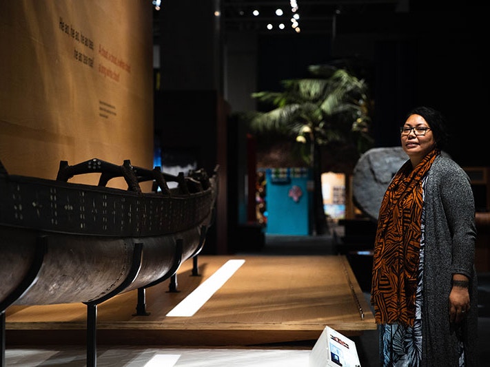 Safua Akeli Amaama, 2020. Photo by Jack Fisher. Te Papa Safua stands to the right of the photo frame in front of a waka