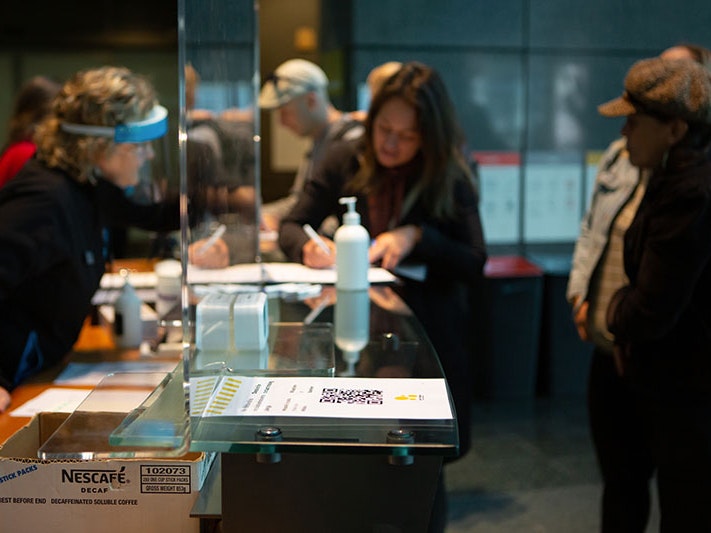 Signing into Te Papa in Alert Level 2, 2020. Photo by Jo Moore. Te Papa (157985) A woman signs into Te Papa