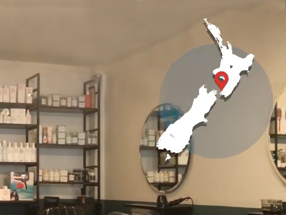 Cutting back on waste - Scout Hair salon A map of New Zealand overlaid on an interior shot of a hairdresser salon. A location marker on the map indicates Raumati South in Kāpiti.