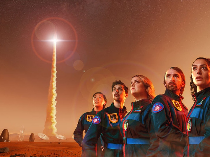 Destination Mars, 2021. Image by Grant Maiden, courtesy of Aotearoa New Zealand Festival of the Arts A group of astronauts look to the skies as a rocket takes off. The sky and ground are red, suggesting they are on Mars