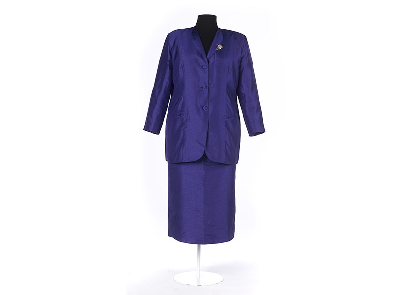 Suit, Woman's, about 1997, Wellington, by Peter Homan. Gift of Dame Jenny Shipley, 2018. CC BY-NC-ND 4.0. Te Papa (GH018264) A purple suit jacket and skirt with a silver brooch, on a white background