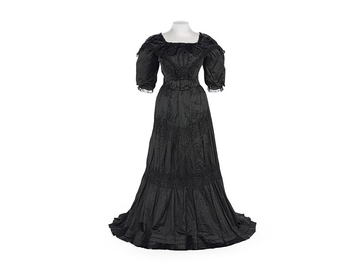 Black evening gown (bodice and skirt), J. Ballantyne and Co., manufacturer(s); about 1895, New Zealand. Te Papa (PC001642) A black satin dress from the 1890s on a white background