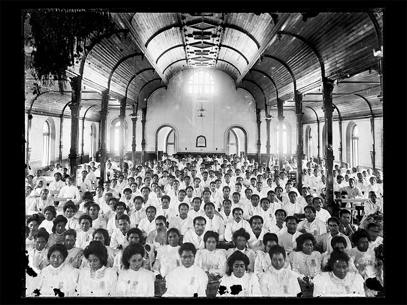Church at Malua, late 1890s, Upolu, by Thomas Andrew. Te Papa (D.000674) A black and white photo of a lot of Sāmoan people dressed in white and sitting in a church