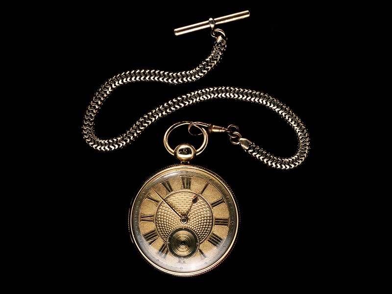 Watch, about 1866, England, maker unknown. Gift of J.W.G. Brodie, 1956. CC BY-NC-ND 4.0. Te Papa (G002300) A pocket watch and chain on a black background