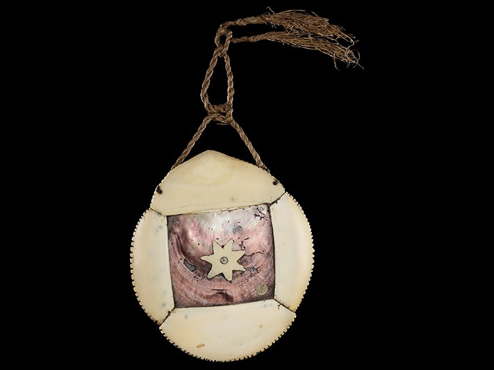 Civavonovono (Breast plate), 1800s, Fiji, maker unknown. Oldman Collection. Gift of the New Zealand Government, 1992. CC BY-NC-ND 4.0. Te Papa (OL000596) A breastplate made of bone and pearl hung on rope on a black background