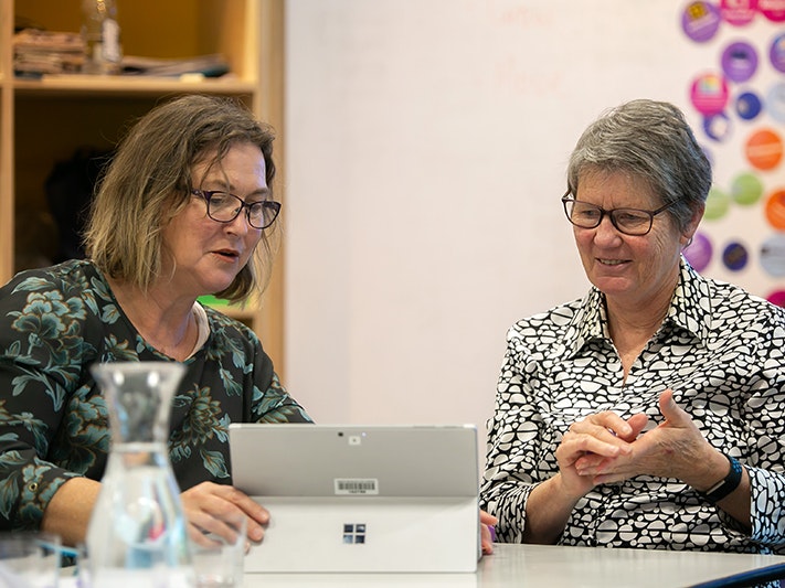 Raranga Matihiko Mentorship Launch, 2021. Jo Moore, Te Papa Two women looking at a laptop and discussing what they're seeing