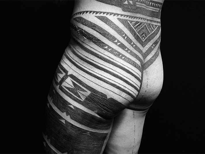 Tātatau faka-Tonga made by Terje Koloamatangi. Photo courtesy of Terje Koloamatangi Black and white photo of the back and leg of a tattooed man