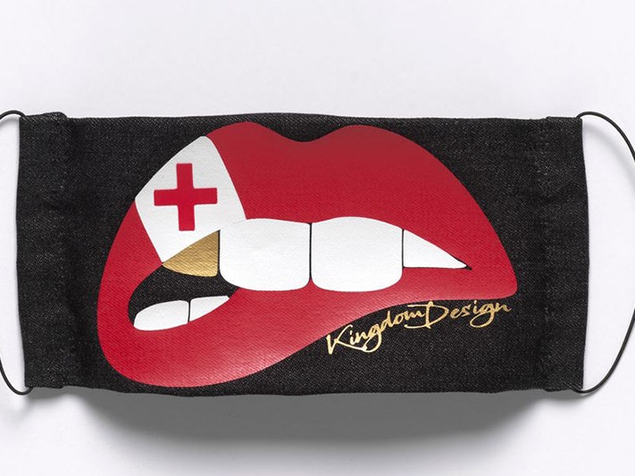Czarina Wilson, Face mask Tonga Flag Nifo Gold (Limited Edition) Prototype, May 2020; Glen Innes. Purchased 2020. Te Papa (FE013563) a black facemask with the image of a mouth with red lips, white teeth and a single gold tooth