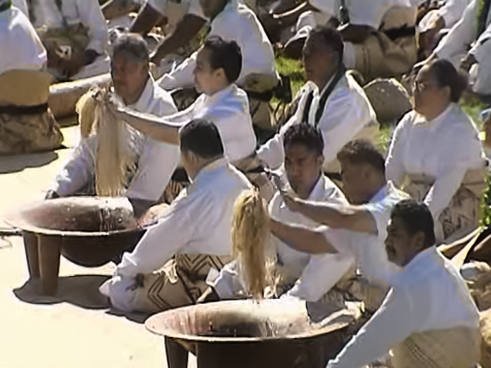 Still from Tales of Te Papa: Kava Bowls and Black Fowls Men sitting on the ground outside performing a ceremony with kava