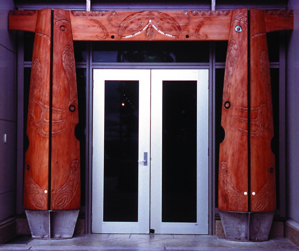 Large silver doors with wooden carving on both sides and the top.
