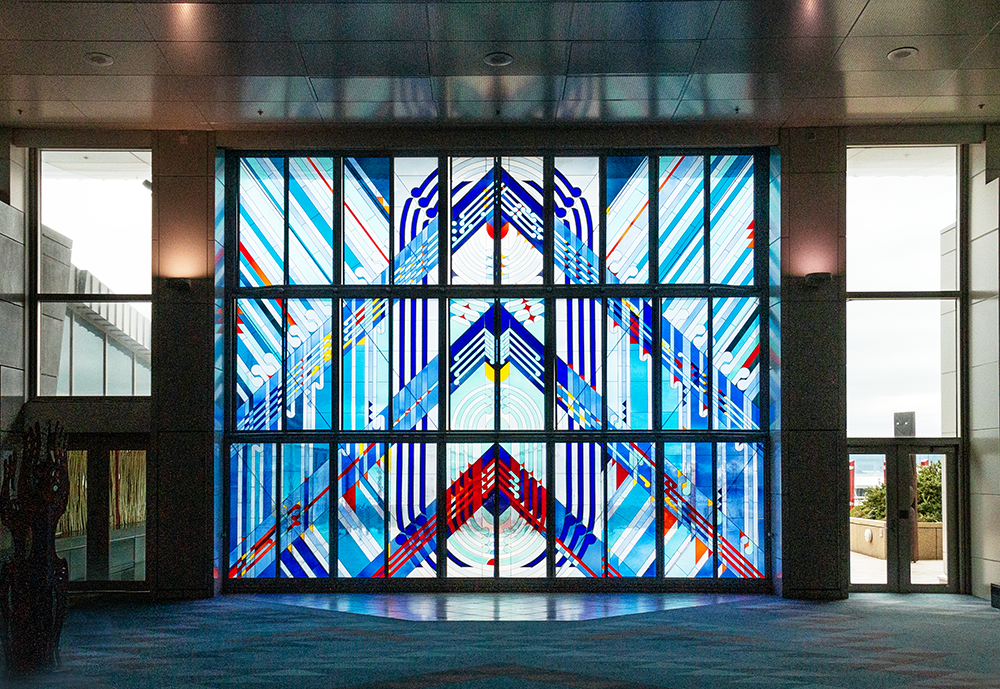 A large stained-glass door which is part of a wall of a large room.