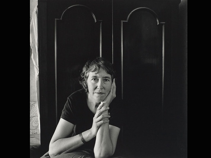 Adrienne Martyn, Ans Westra, Wellington, 1987. From the series: Artists' portraits,1987. Purchased 1988. Te Papa (O.003817) A black and white portrait of a woman looking at the camera with her chin resting on her hand.