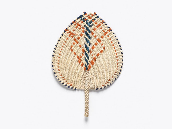 Ili (fan), Tokelau Islands, by Meaalofa Faleasiu. Co-collected, 2017. Te Papa (FE013268) Fan made of coconut and pandanus leaves, featuring an orange and blue pattern woven throughout