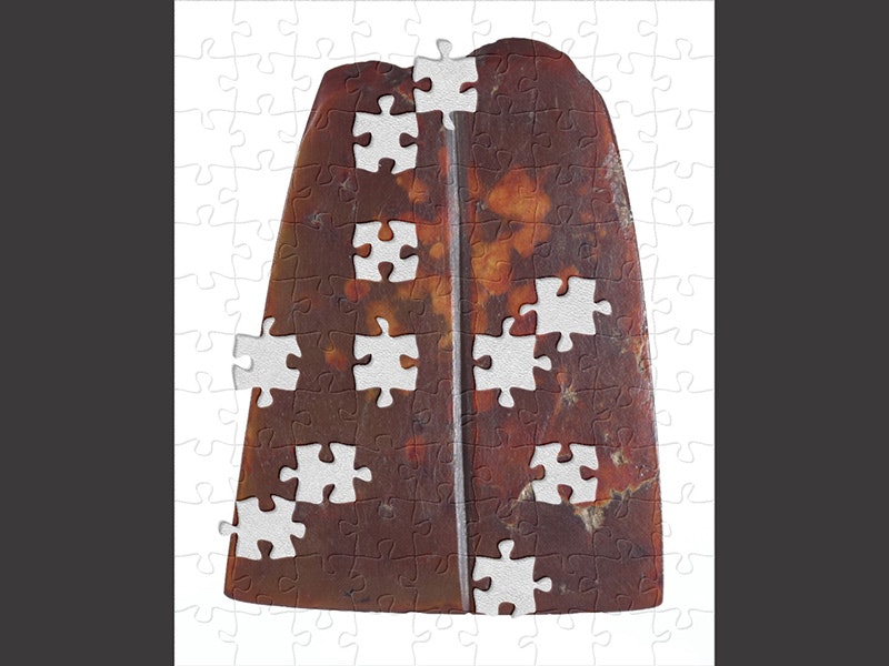 Toki pounamu (nephrite adze blade), Unknown,1500–1820, Te Papa (ME024039) A red stone shaped like an adze on a white background