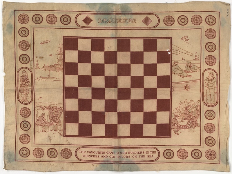 Draughts board, 1915, maker unknown. Gift of Mr H. Ackerley, 1966. Te Papa (GH002573) A draughts board on a piece of material. There is text on it referring to soldiers serving overseas.