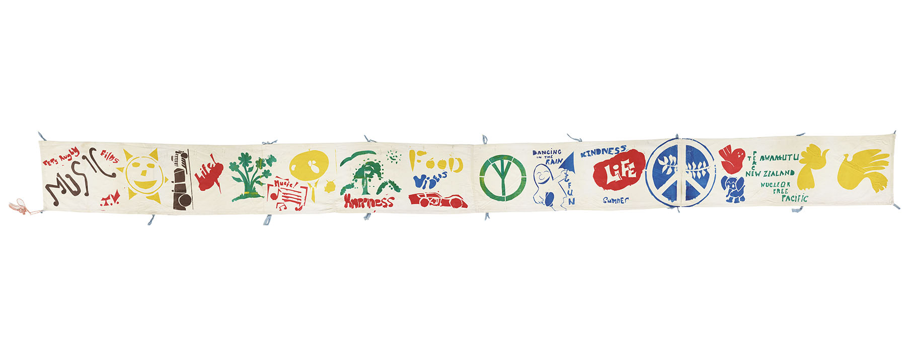 Banner featuring lots of painted on symbols and words: trees, peace signs, doves, the sun, and the words “music”, “life”, “kindness”, “happiness”, etc.