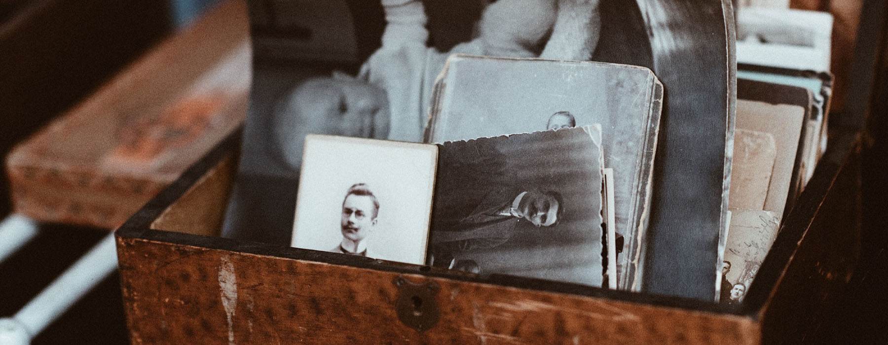 Small wooden box containing a collection of old black and white portraits