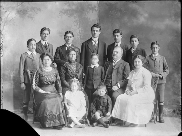 Portrait of Kronfeld Family: Louisa and Gustav with their ten children and two grandchildren, 1910-1919, by Herman John Schmidt. Auckland Libraries Heritage Collections via Digital NZ A black and white studio photograph or a large family in between 1910 and 1930