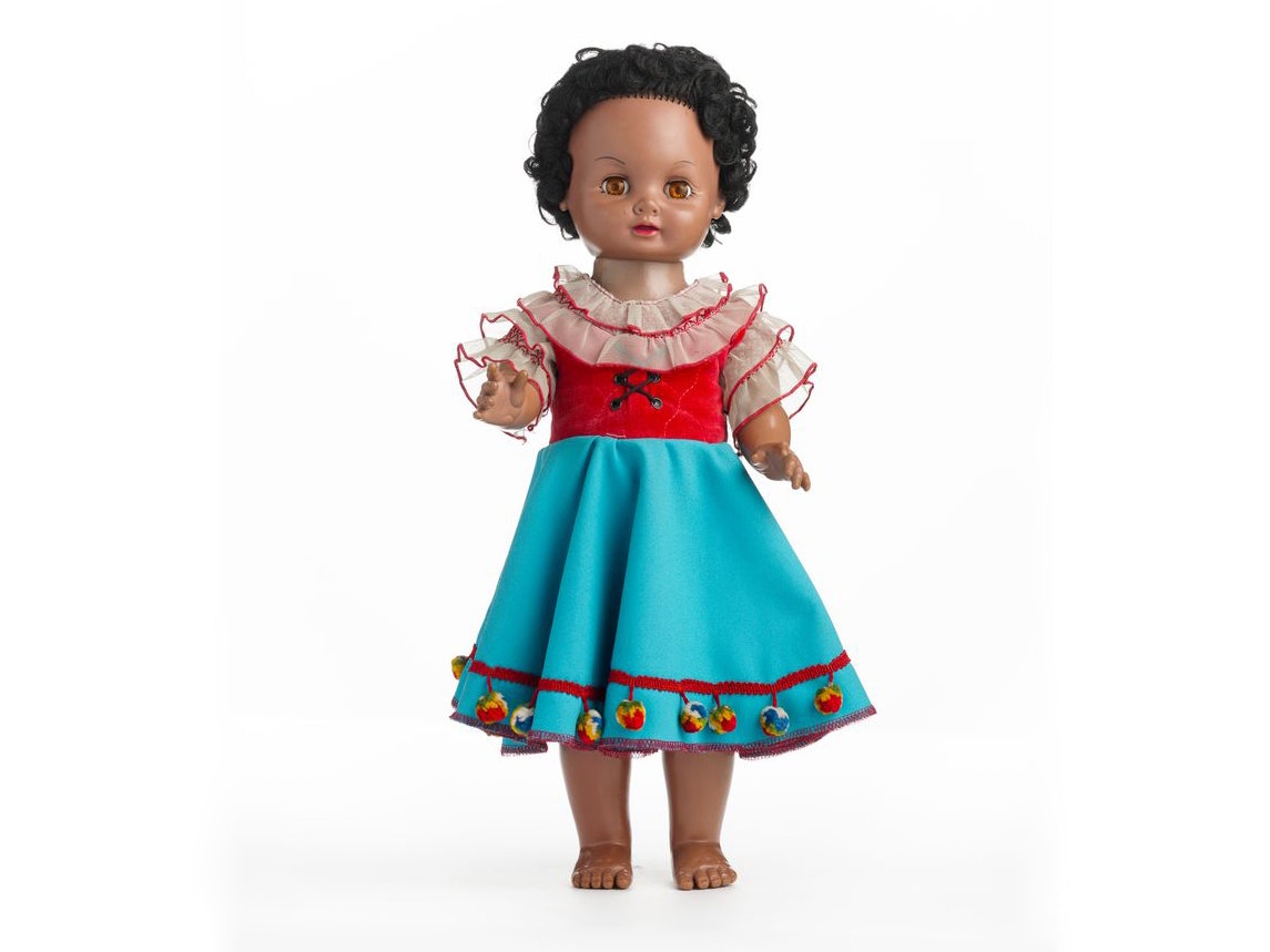 Manu, Unknown; maker/artist; 1968; New Zealand. Gift of Whitebait TV Productions, 2004. Te Papa (GH014509/1) A brown doll – it is a girl in a dress and top. She has black curly hair.