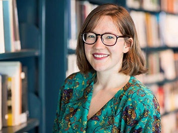 Katie Cooper A head and shouldrs photo of a woman with brown hair and wearing glasses