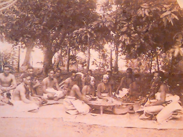 Rotuman Marriage, 1890-1910, by Thomas Andrew. Te Papa (O.001003) Sepia image of 15 people sitting on flax mats under trees