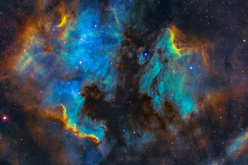 A colourful photo of a star sky with rainbow colours on the clouds