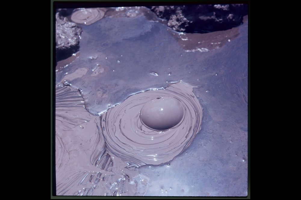 A photo of a single bubbling mud pool.