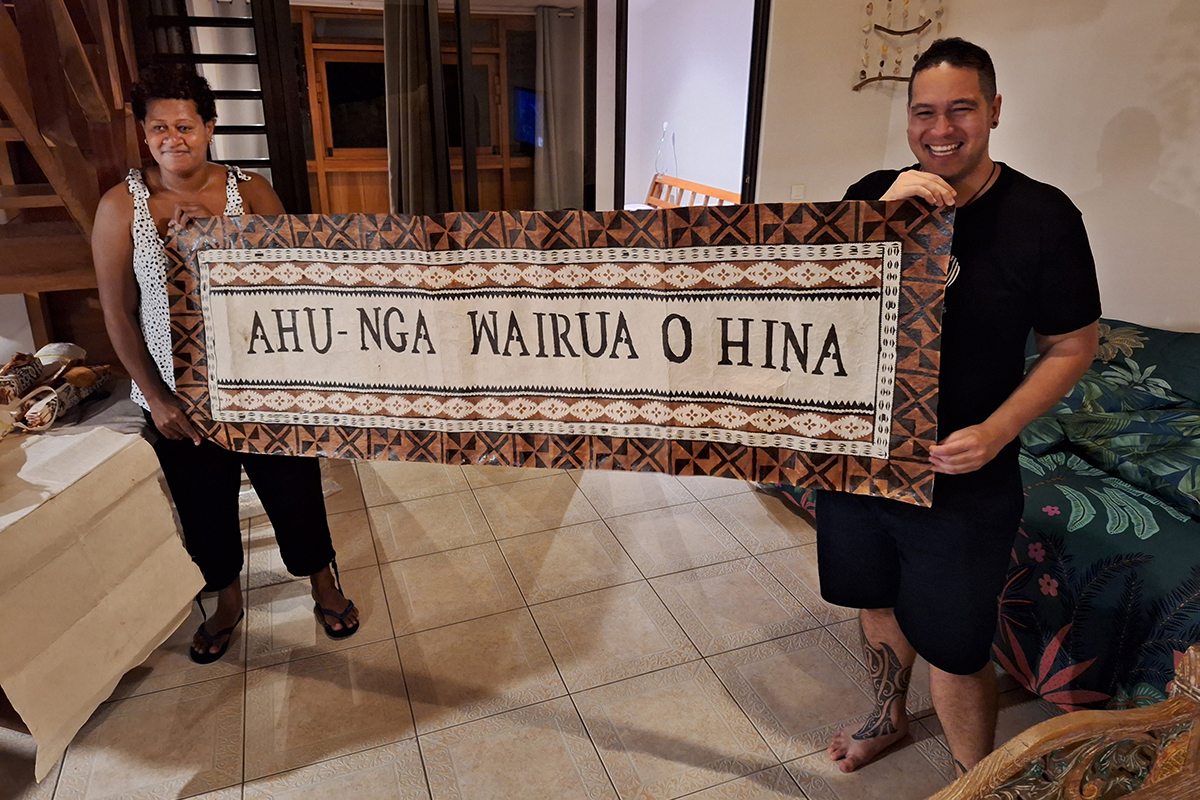 Two people are holding a banner that says 'Ahu-Nga Wairua o Hina