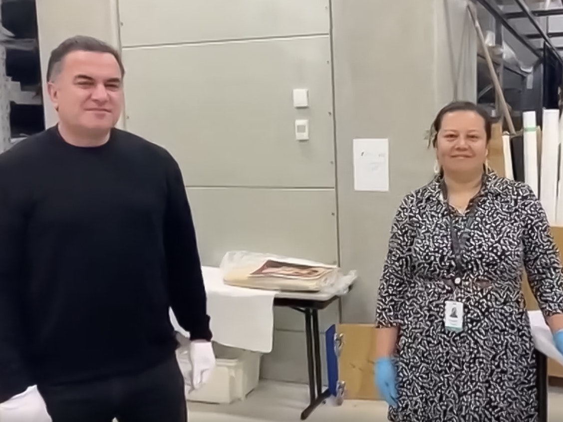 Sean Mallon and Emelihter Kihleng. Screen grab from 531 radio video A man and a woman are standing in a museum store room. Both are looking at the camera.