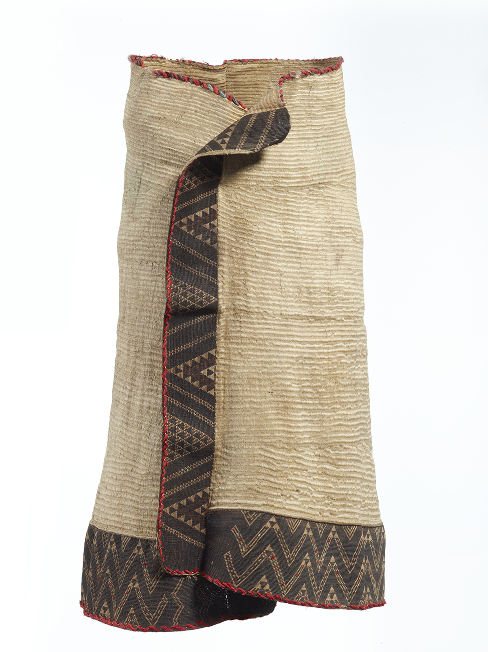 A woven cloak adorned with decorative two- or three-ply threads. It is woven with muka or flax fibre.with narrow side borders and a deep lower border of tāniko weaving (geometric patterning) in darker colours.