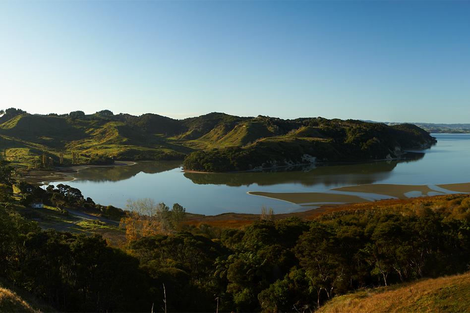 A panoramic photo of a still harbour and low-lying hills