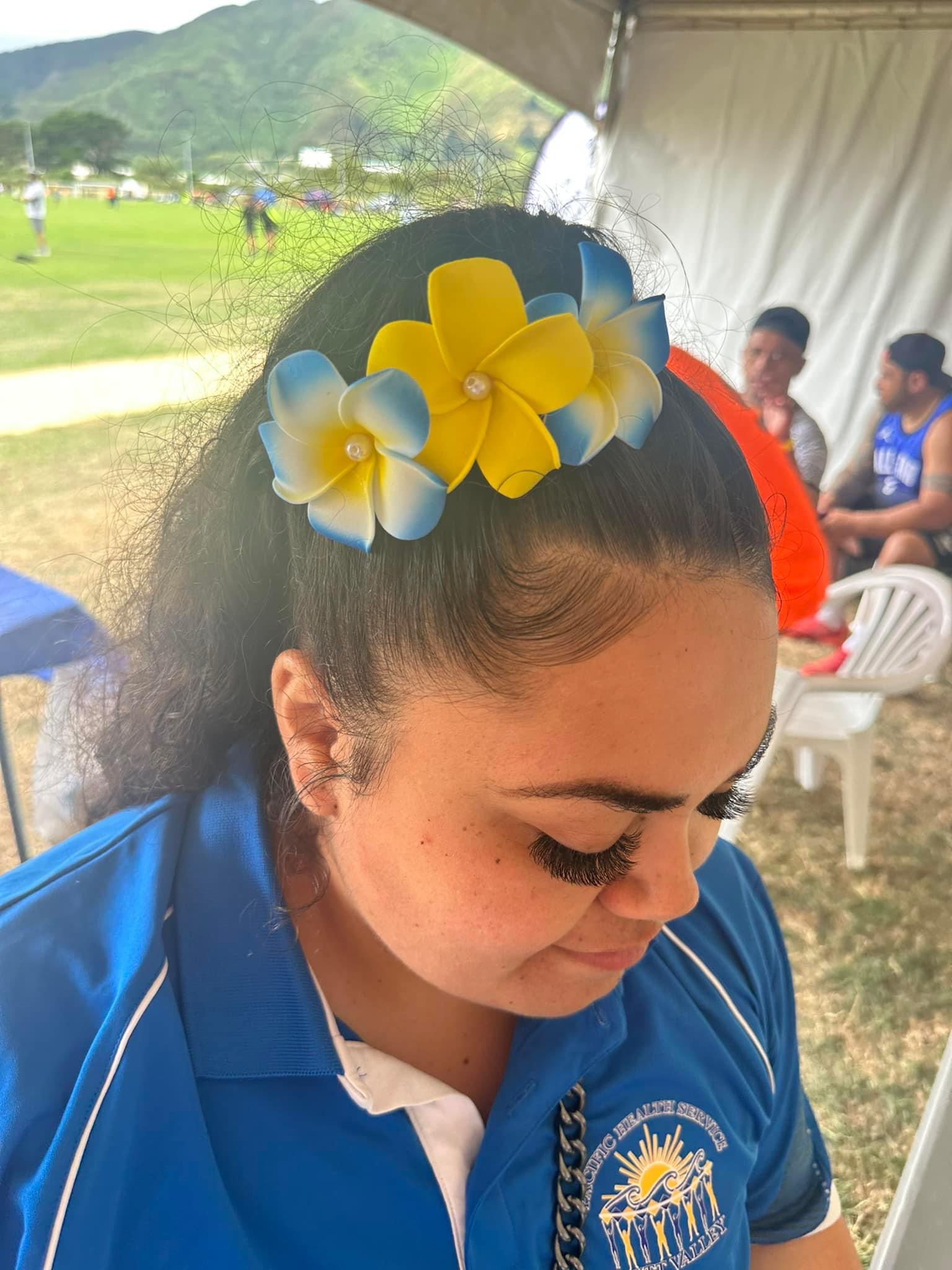 A side view of a woman with a floral clip in her hair.