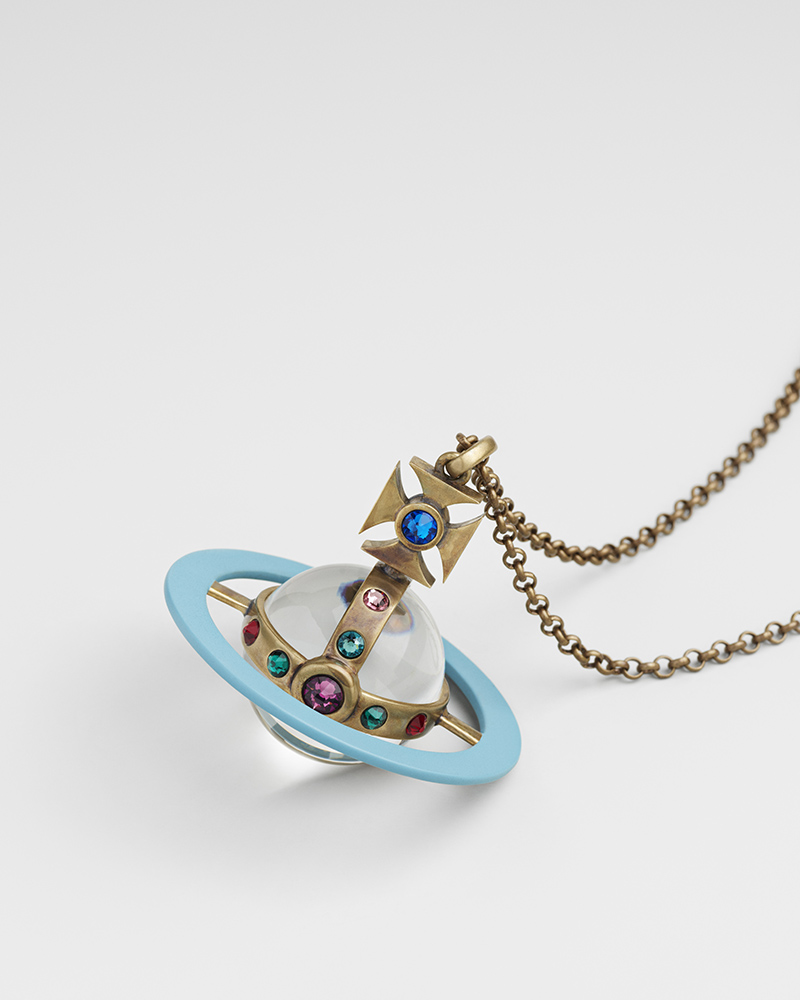 A pendant resembling a planet with a blue ring, gold details, and multicolored gems, hanging from a gold chain.