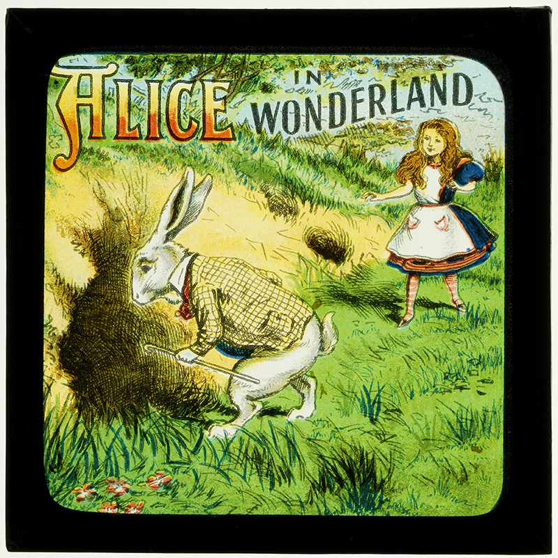 A picture from the Alice in Wonderland with Alice following the white rabbit to a hole in the ground.