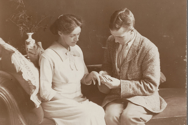 Sepia photo of a man putting a ring on a woman.