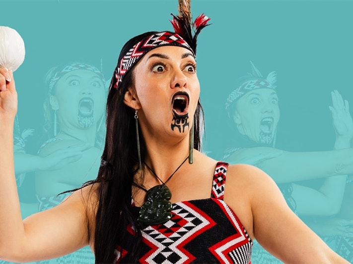 Te Matatini Fan Zone promotional image A woam with a chin tattoo and cultural dress is holding a poi (ball on a string) in the air with one hand. She is mid chant and is performing before an unseen audience. There is an opaque photo in the background of three other women doing the same thing.