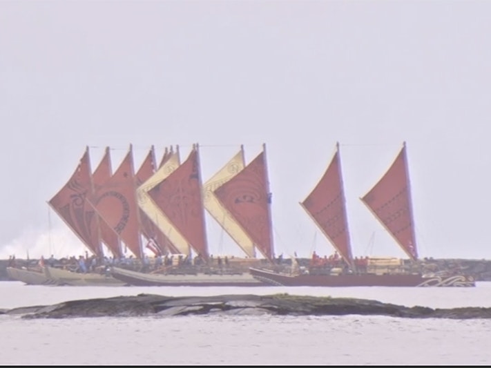 Still from Te Mana o te Moana, 2011. Courtesy of Danee Hazama Several double-hulled waka with red and yellow sails are on the ocean.